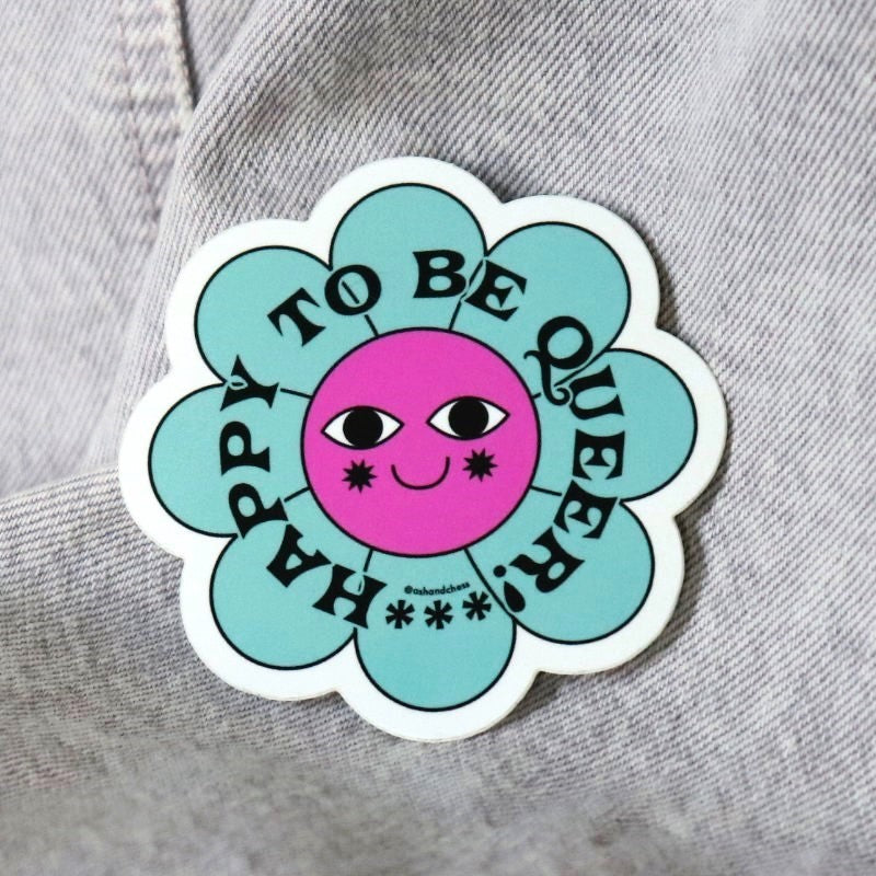 sticker of a flower that says "happy to be queer"