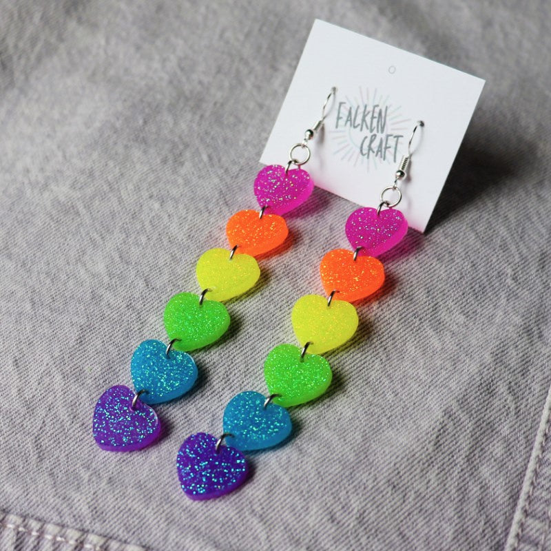 dangly earrings with hearts in the colors of the pride flag