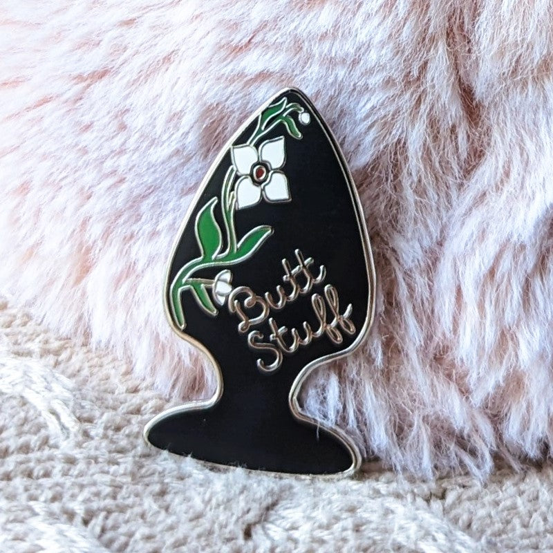 funny enamel pin of a butt plug with flowers and the words "butt stuff"