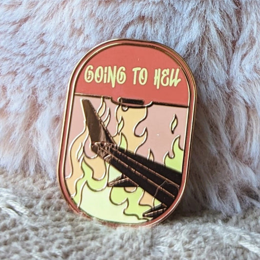 funny enamel pin of a plane flying over fire and the words "going to hell"