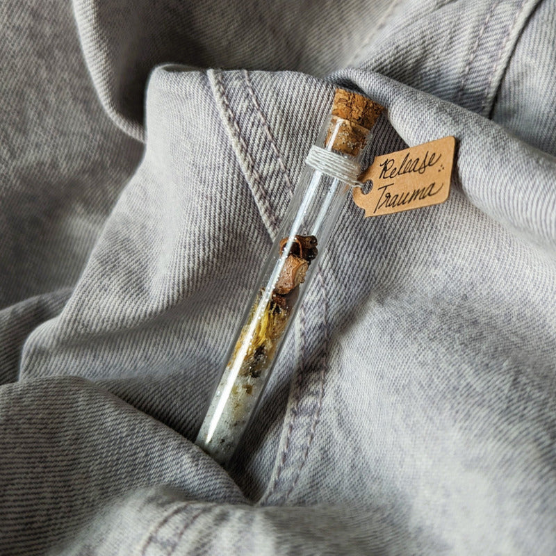 cute tiny vial filled with materials for a trauma release spell