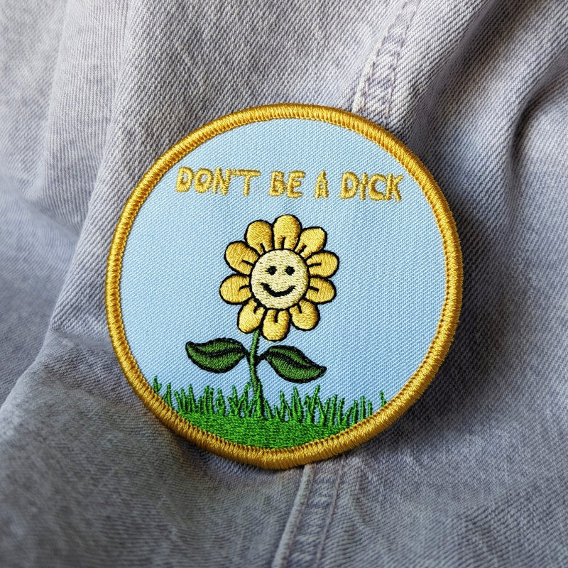 funny embroidered patch featuring a happy flower that says "don't be a dick"