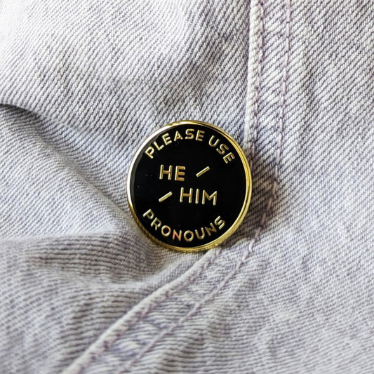 cool enamel pin that says "please use he/him pronouns"