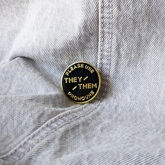 cool enamel pin that says "please use they/them pronouns"