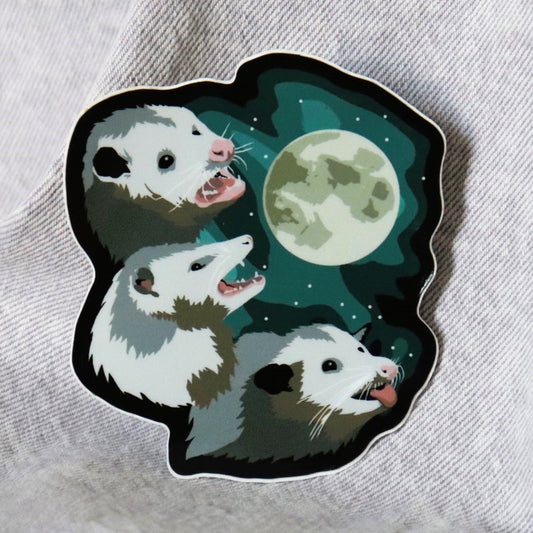 funny sticker of a moon with three opossums screeching beneath it