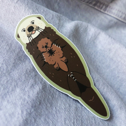 cute sticker of a floating sea otter and its pup