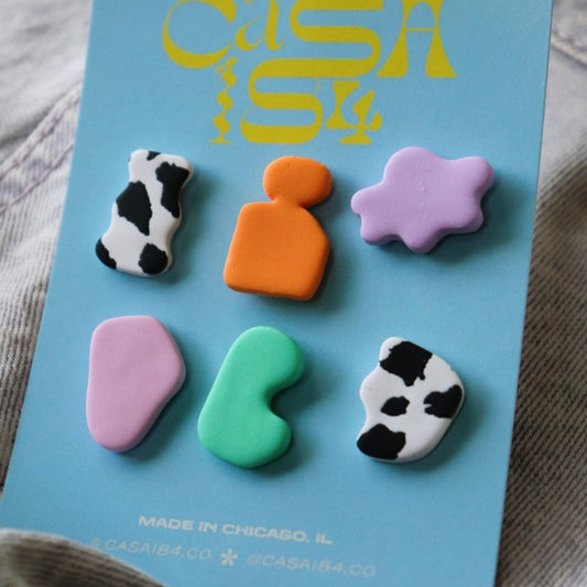 card of 6 polymer clay stud earrings, all brightly colored and mismatched