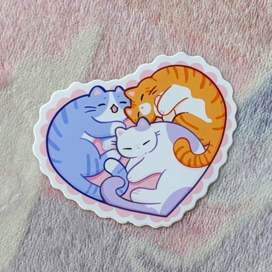 adorable sticker of 3 cuddling cats in the shape of a heart