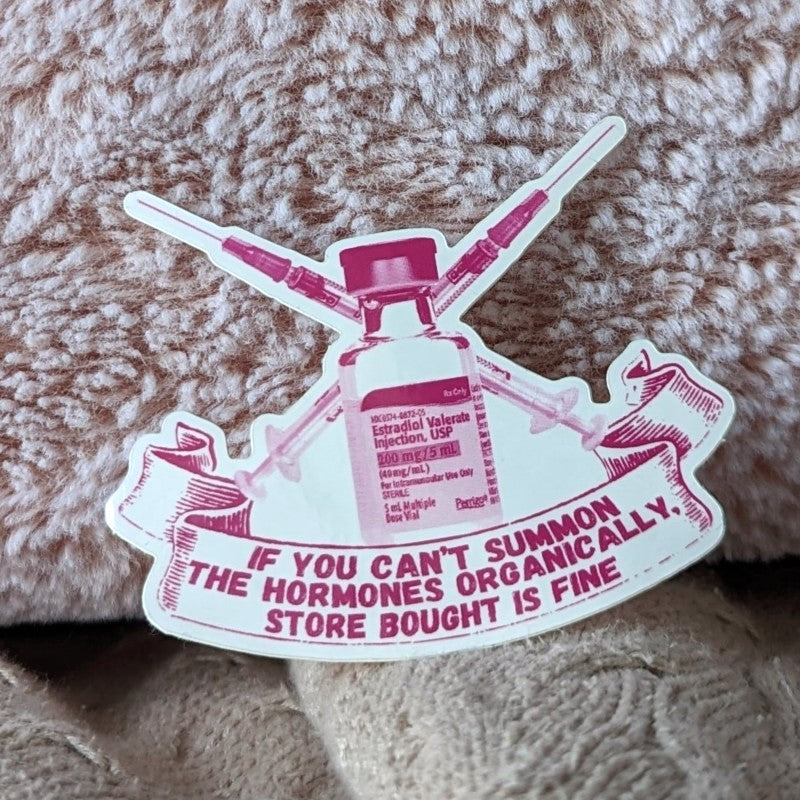 sticker featuring a vial of estrogen, syringes, and the words "if you can't summon the hormones organically, store bought is fine"