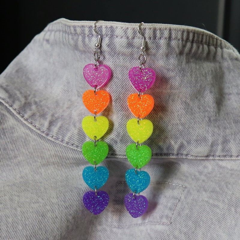 dangly earrings with hearts in the colors of the pride flag