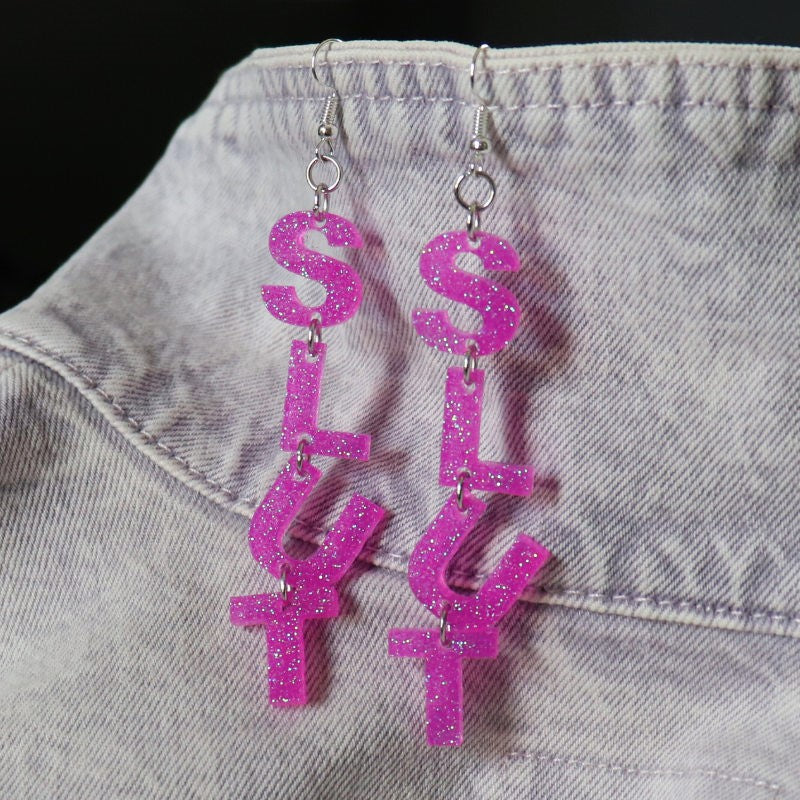 dangly earrings with letters that spell out "slut"