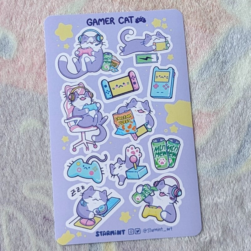 sheet of stickers showing cats playing video games and eating gamer snacks