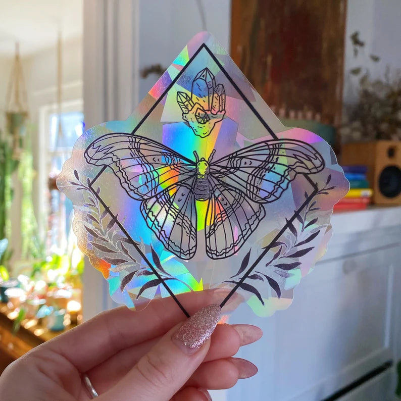 a clear, suncatching sticker of a moth and a chunk of crystals