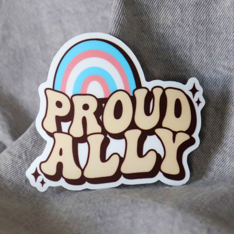 sticker that says "proud ally" under a trans-colored rainbow