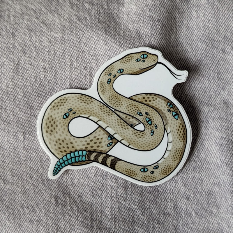 cool sticker of a rattlesnake with many blue eyes