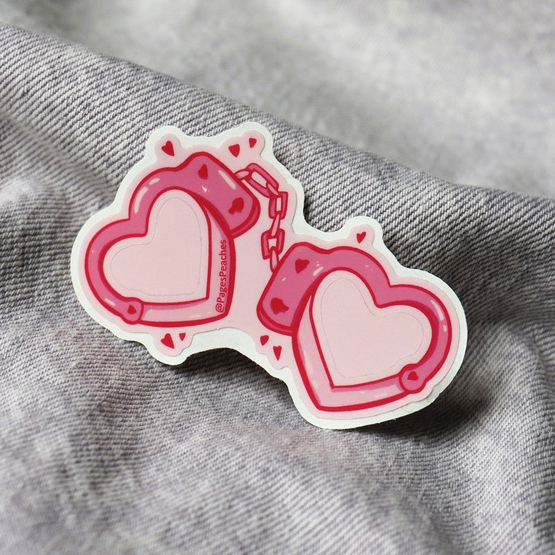 tiny sticker of heart-shaped handcuffs