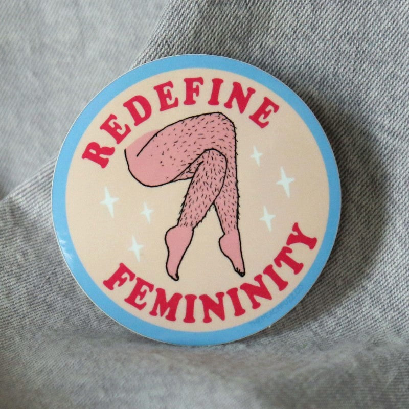 sticker depicting hairy legs and the words "redefine femininity"