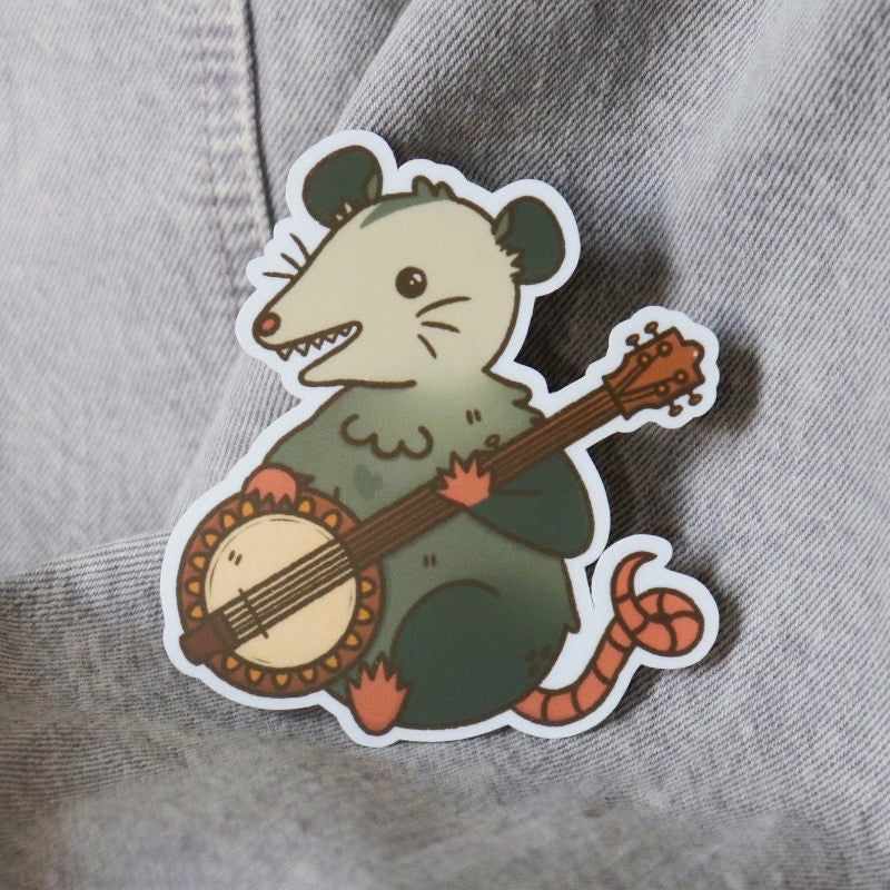 cute sticker featuring an opossum playing a banjo