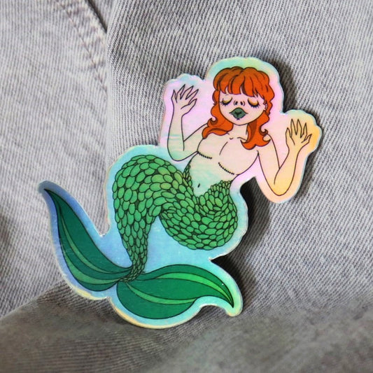 a pretty holographic sticker of a mermaid with top surgery scars