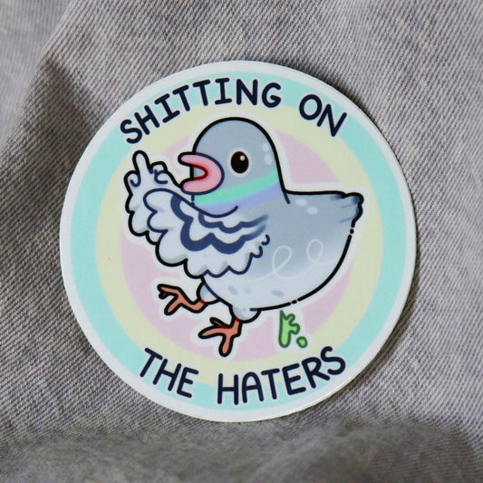 funny sticker of a pigeon pooping and the words "shitting on the haters"