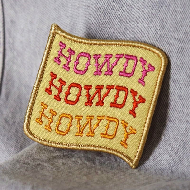 square flag-shaped iron-on patch with the words "howdy howdy howdy"